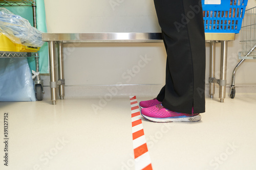 Medical worker standing behind safety demarcation tape photo