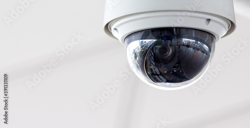Closeup of white dome type cctv digital security camera installed on ceiling for observation Fototapeta