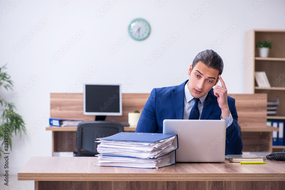Young male employee unhappy with excessive work Young male employee unhappy with excessive work