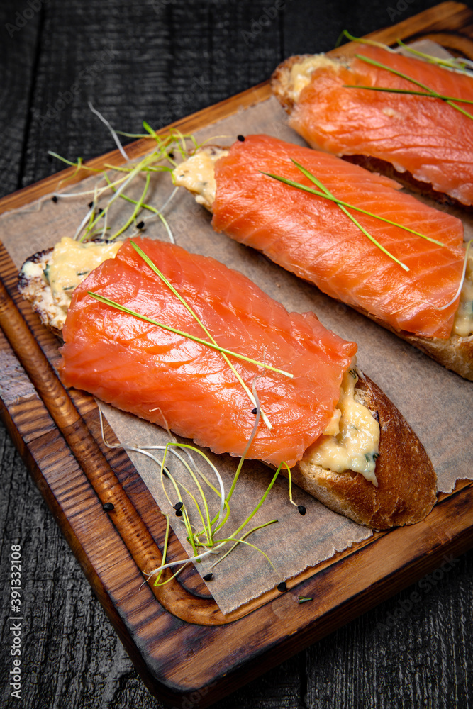 Bruschetta with cheese, avocado and salmon fillet. Delicious nutritious healthy snack. Festive table with delicious food. Bruschetta with cheese, avocado and salmon fillet. Delicious nutritious healthy snack. Festive table with delicious food.