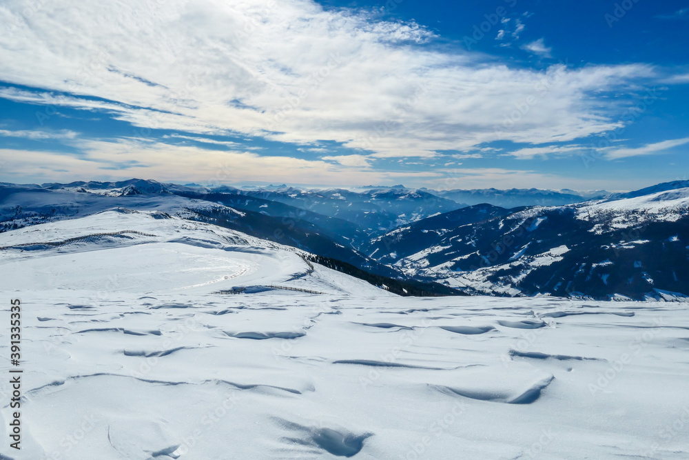 A panoramic view on snow capped Alps in Austria, seen from Katschberg Ski Resort in Austria.The slopes are covered with fresh, powder snow. Idyllic winter landscape. Sunny day