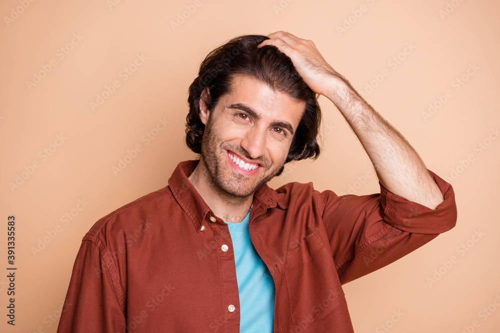 Photo of cute beaming young guy dressed casual brown clothes smiling arm hair isolated beige color background Photo of cute beaming young guy dressed casual brown clothes smiling arm hair isolated beige color background