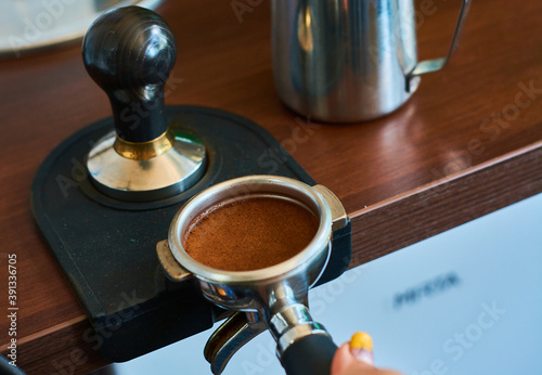 The process of temper coffee in holder, making espresso on coffee machine. photo