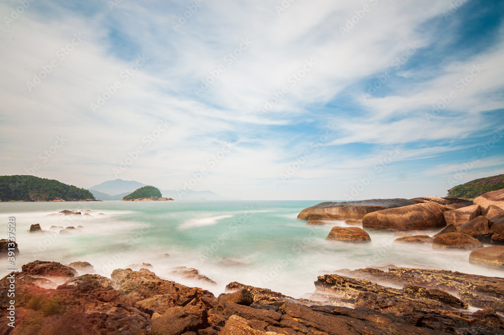 View of the sea with rocks from the natural pools of Trindade, Paraty, RJ. Long exposure shot.