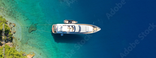 Aerial drone ultra wide panoramic photo of luxury yacht anchored in tropical exotic island with crystal clear turquoise sea and pine trees © aerial-drone