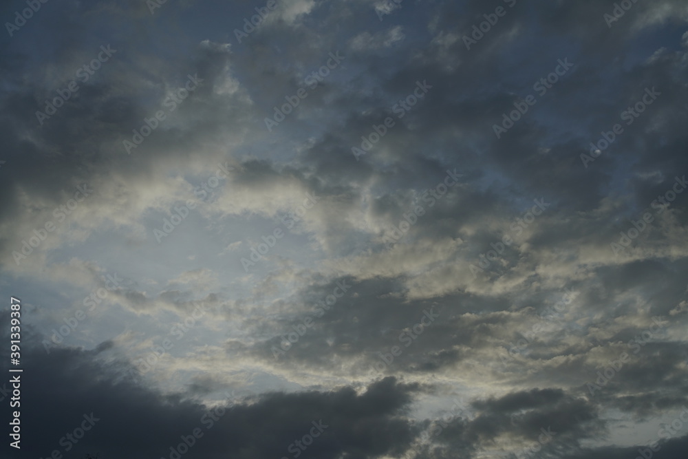 Abendliche schöne helle, dunkle, blaue und weiße Wolken in einer Serie