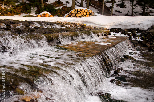 Mountain stream running through a wooden water treshold, Żywiec Beskids (Beskid Żywiecki), Carpathian Mountains, Poland photo
