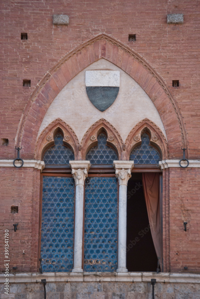 
historic arched window with stone columns on the facade of a red brick building