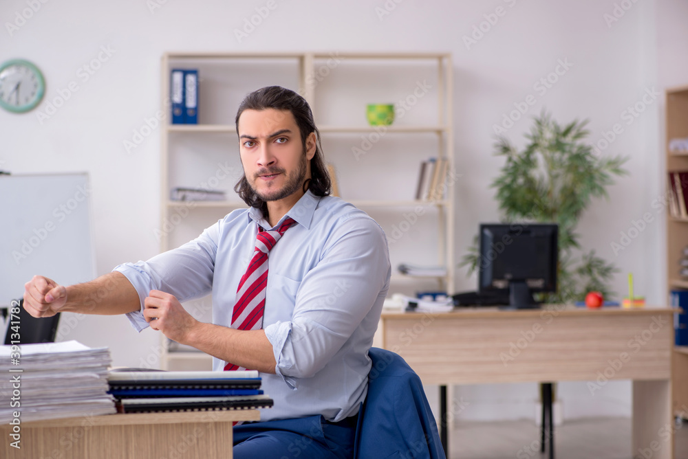 Young male employee unhappy with excessive work Young male employee unhappy with excessive work