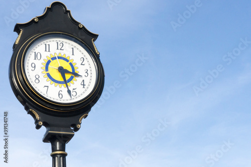 Close up of a vintage street clock with lots of blue sky for text