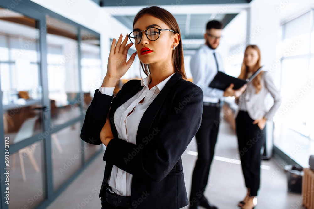 Business young woman with her staff, group of people in the background in modern office indoors