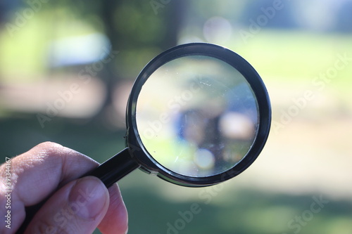magnifying glass in hand on the grass. Search concept. Natural living concept