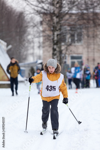 Foto Young Caucasian girl running cross-country ski at competition, winter activities