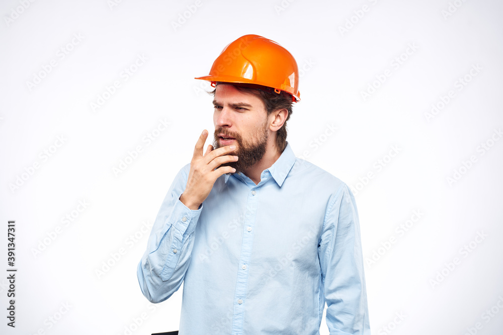 Man in blue shirt orange hard hat professional construction safety engineer Man in blue shirt orange hard hat professional construction safety engineer
