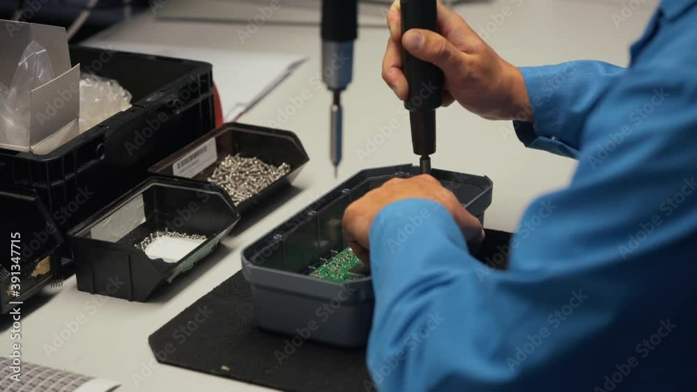 Worker in electronics manufacturing soldering a component