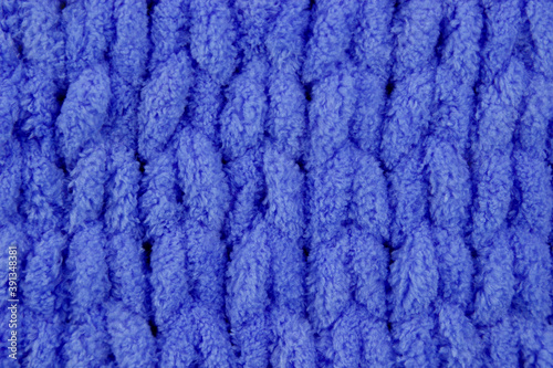 Close-up seamless knitted fabric of blue color, cozy winter knitted background. Unusual abstract texture background. Winter mood and cozy time at home © New Happy World