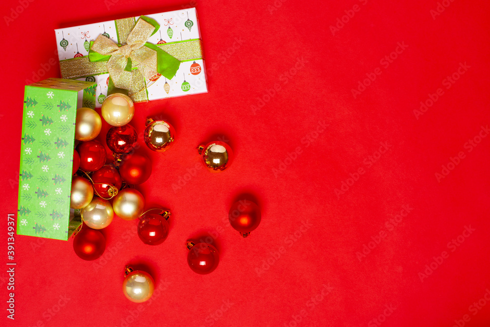 mock up of an open green gift box on the side with scattered red and gold balls for the Christmas tree on a red background. mock up of an open green gift box on the side with scattered red and gold balls for the Christmas tree on a red background.