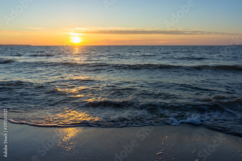 Sunset over the sea. Reflection of sunlight in the sea waves. The sky in the sunset. Baltic sea.