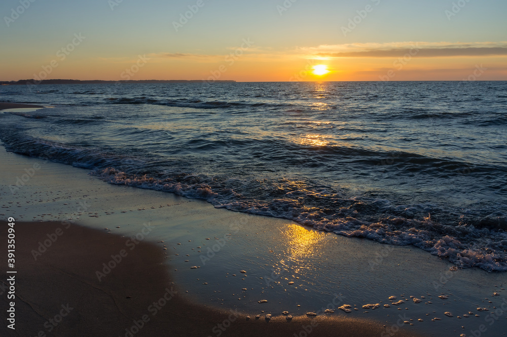 Sunset over the sea. Reflection of sunlight in the sea waves. The sky in the sunset. Baltic sea.