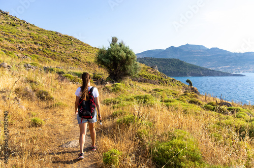 Woman walking on scenic seashore, Lesbos, Greece