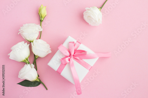 Top view of  gift box, white and pink flowers on the pink  background © Liudmyla