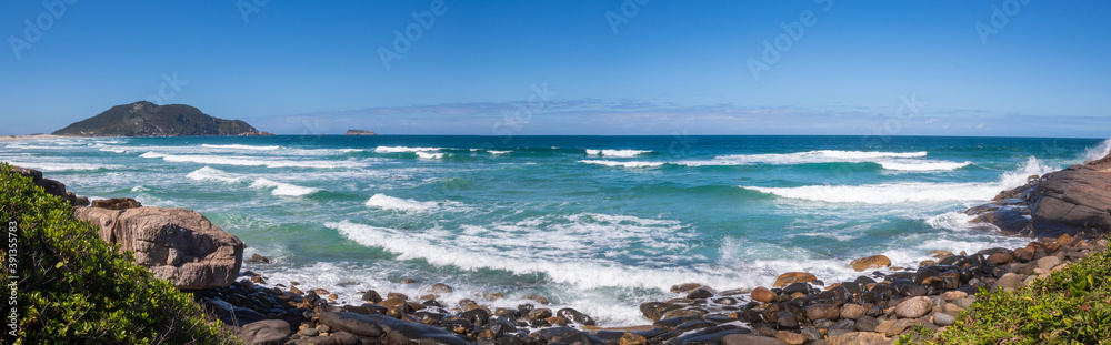 Mar azul batendo nas pedras de uma Praia tropical do Brasil,  ilha de Florianópolis, Praia do Santinho,  Florianopolis,  Santa Catarina