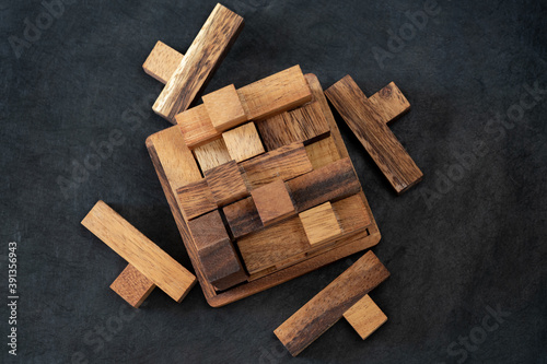 Tableau sur toile Wooden block brain teaser on dark background