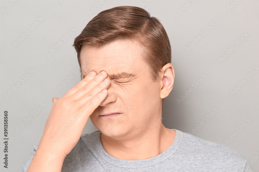 Portrait of tired man touching bridge of his nose with hand Portrait of tired man touching bridge of his nose with hand