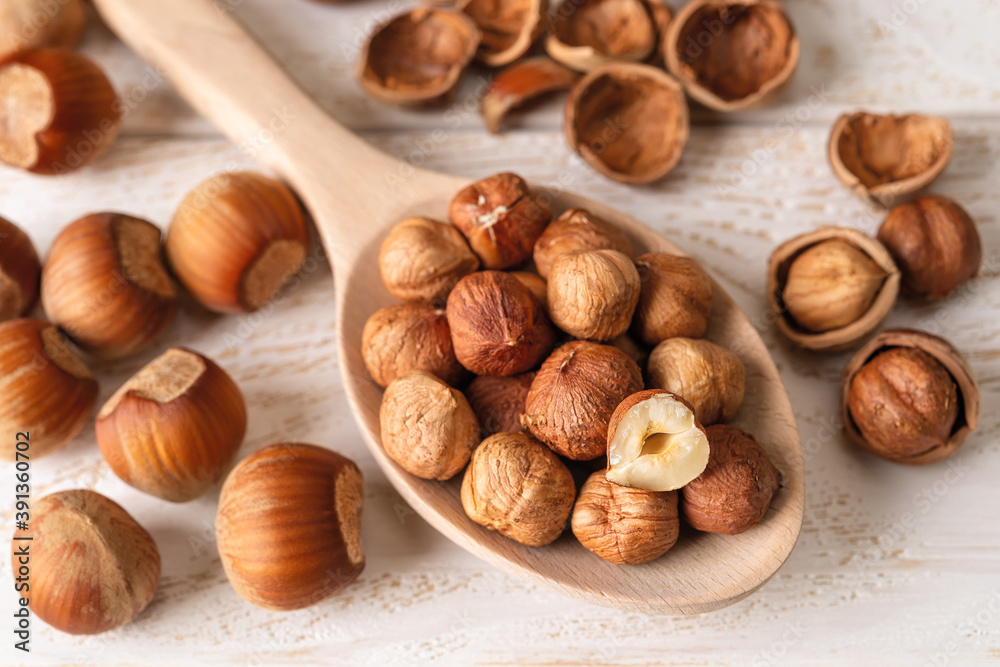 Hazelnut kernels in a large wood spoon over white wood table. Healthy vegetarian eating, antioxidant and protein source. Ketogenic and raw food diets ingredient. Hazelnut kernels in a large wood spoon over white wood table. Healthy vegetarian eating, antioxidant and protein source. Ketogenic and raw food diets ingredient.