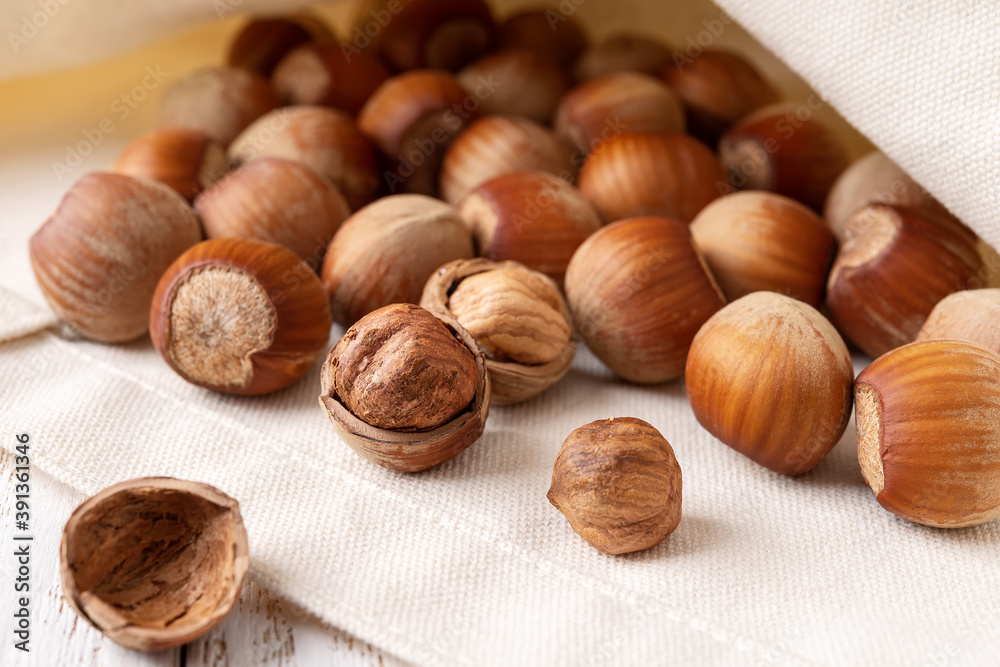 Unshelled hazelnuts in a jute bag close-up. . Healthy vegetarian eating, antioxidant and protein source. Ketogenic and raw food diets. Harvest concept. Unshelled hazelnuts in a jute bag close-up. . Healthy vegetarian eating, antioxidant and protein source. Ketogenic and raw food diets. Harvest concept.