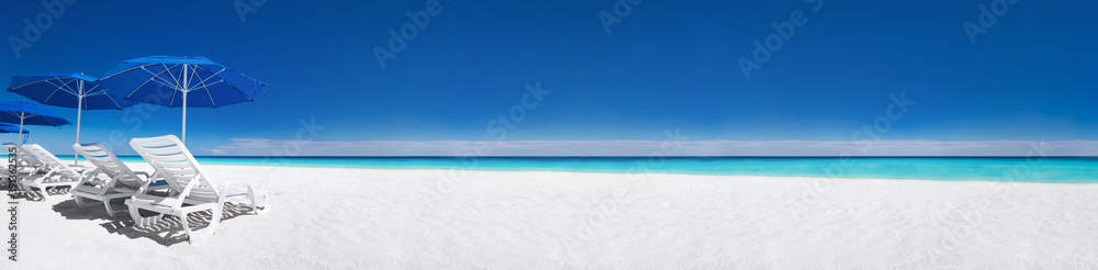 Caribbean beach with blue sun umbrellas and white beds. Tropical vacation - obrazy, fototapety, plakaty 