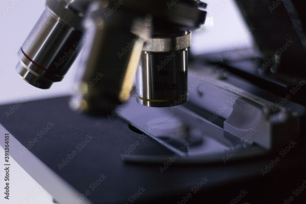 close-up side view of a biological microscope, while analyzing a hair. close-up side view of a biological microscope, while analyzing a hair.