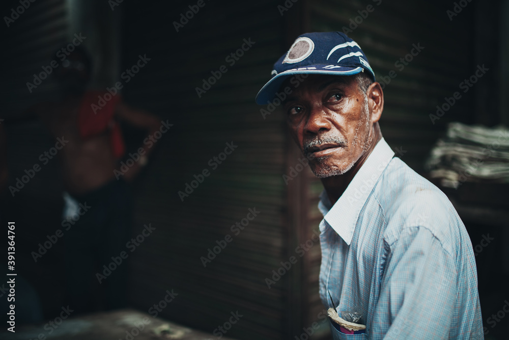 Black man looking away from camera in a dark alley Black man looking away from camera in a dark alley