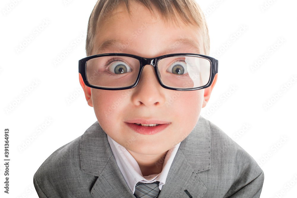 Portrait of a funny child in glasses and a business suit on a white background. Smart child in suit and glasses looking at camera with his big eyes