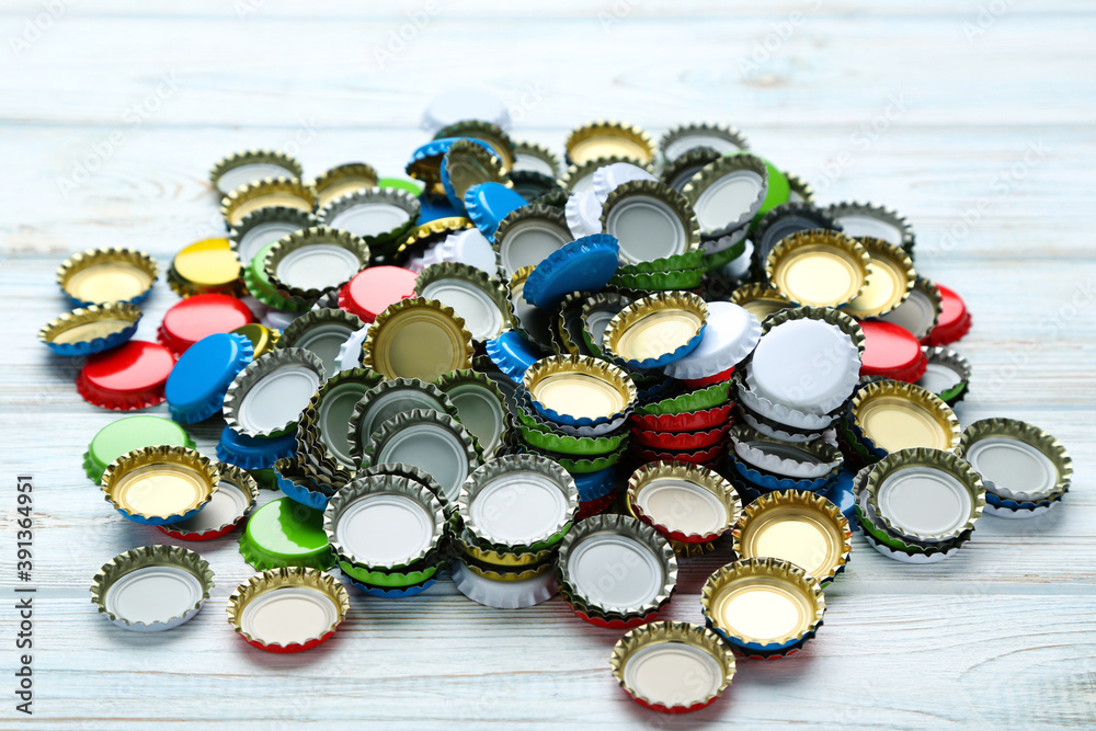 Colorful bottle caps on white wooden table Colorful bottle caps on white wooden table