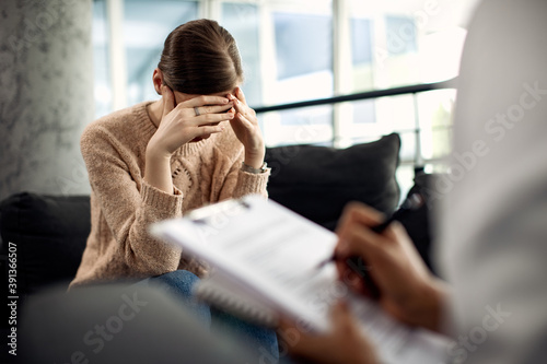 Depressed woman having psychotherapy session at doctor's office.