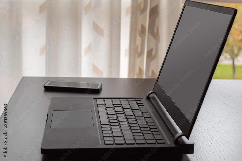 laptop and mobile phone on a table ready to work from home and use new technologies