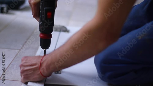 Wallpaper Mural process of apartment renovation. fettler drills nails with a electric screwdriver into door hinges on the facade. unrecognizable men. remodeling, doing repairs. FullHD footage. Torontodigital.ca