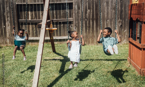 Siblings Embracing On Swing Set photo