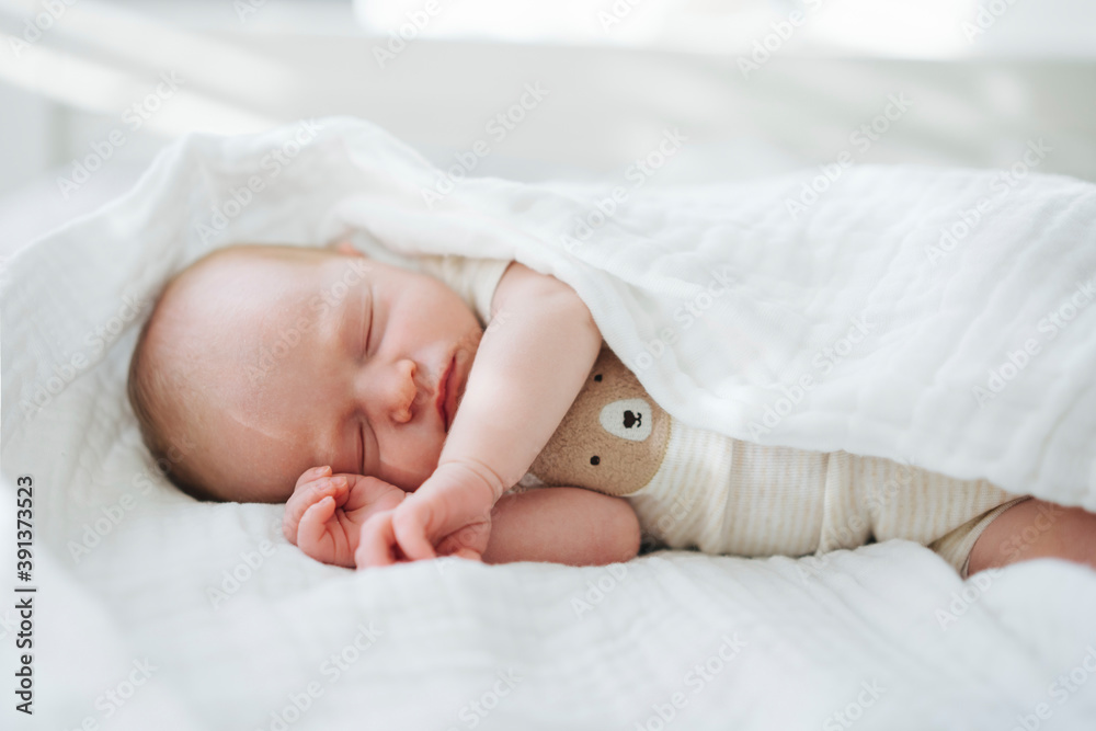 Cute infant in bodysuit sleeping under blanket Cute infant in bodysuit sleeping under blanket