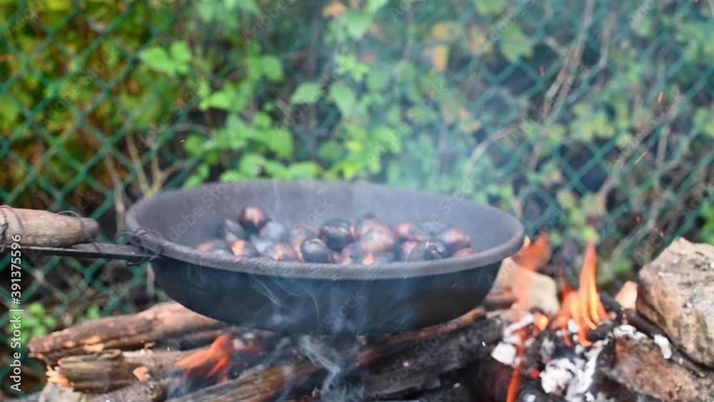 Traditional Italian autumn delicacies cooked outdoors. Roasted chestnuts and maroni over the fire in steel pan High quality FullHD footage . Soft focus Traditional Italian autumn delicacies cooked outdoors. Roasted chestnuts and maroni over the fire in steel pan High quality FullHD footage . Soft focus