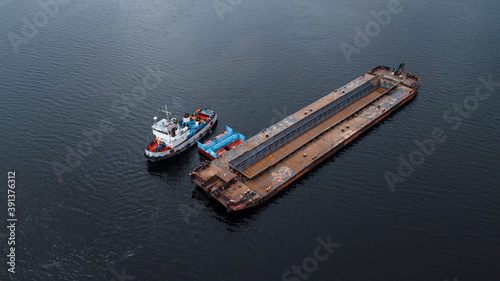 Top-view of a small ship near the empty barge