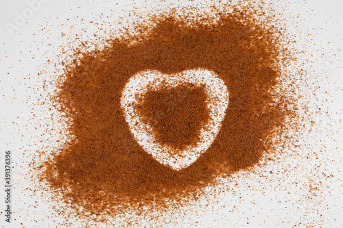 Coconut palm sugar is chaotically scattered on a surface with a halo in the shape of a heart photo