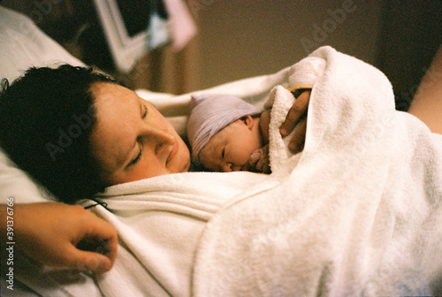 sweet little baby girl just born and laying on breast of mother