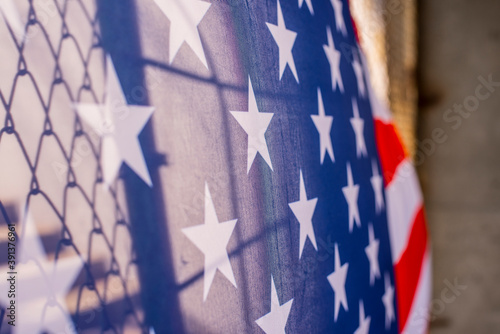Foto Illegal immigration concept  Background of transparent American USA flag behind a chain link fence and concrete stairway