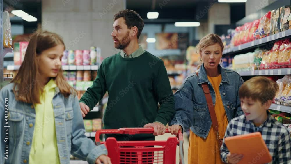 Caucasian happy family of parents and two children shopping delicious good in organic supermarket grocery store. Togetherness. Shopping weekend.