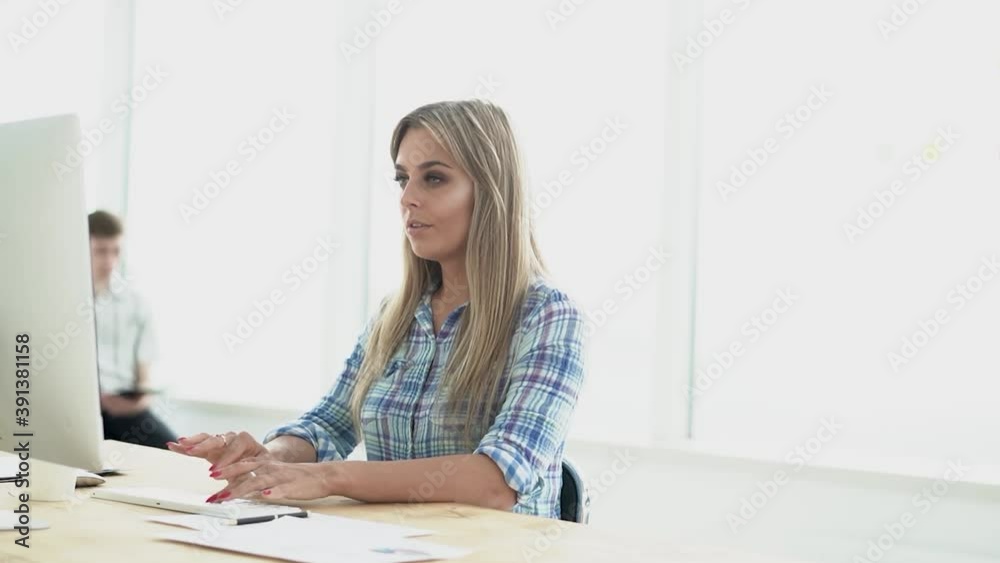 young woman is working on a computer in a modern office. young woman is working on a computer in a modern office.