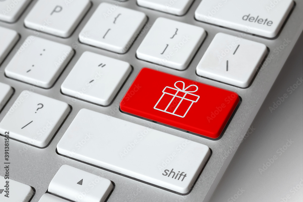 Christmas online shopping. Keyboard with gift symbol key - online Christmas present shopping concept. E-commerce concept. Computer, laptop. Shop online, buy now Christmas online shopping. Keyboard with gift symbol key - online Christmas present shopping concept. E-commerce concept. Computer, laptop. Shop online, buy now