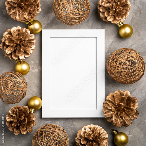 Christmas composition with empty picture frame. Golden ornament, pine cones decorations. Mock up greetings card template