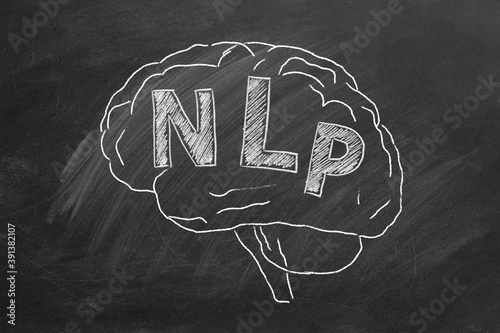 Chalk drawing of the human brain in the blackboard with lettering NLP inside. photo